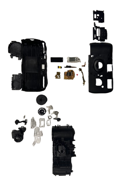 Zerlegte Teile einer Einwegkamera, übersichtlich angeordnet (Knolling)